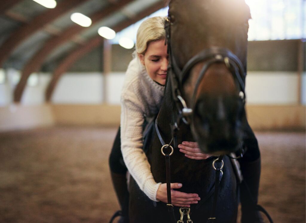 Donna che abbraccia un cavallo